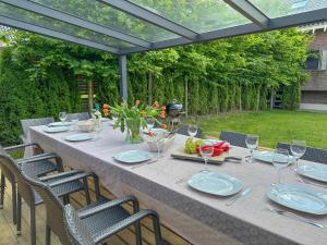 una mesa con platos y copas de vino en un patio en Weidezicht, en Odiliapeel