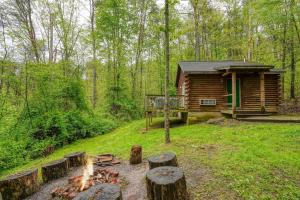 a log cabin with a fire in front of it at Blue Rose Cabins - Big Woody Cabin in Logan