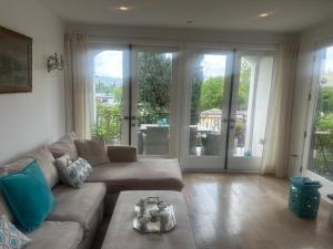 a living room with a couch and sliding glass doors at Elegant Apartment - central location in Los Angeles