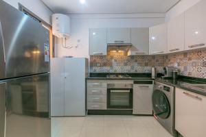 La cuisine est équipée de placards blancs et d'un lave-vaisselle. dans l'établissement ZARI Jaouhara, à Marrakech