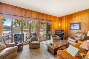 sala de estar con muebles de cuero y vistas al agua en New* 70s Lakefront condo - dock - pool - beach -, en McCall