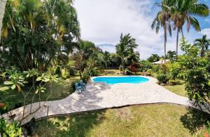 a swimming pool in a yard with palm trees at Hinakena Colonial Villa in Papara