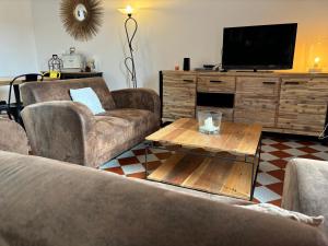ein Wohnzimmer mit 2 Sofas und einem Flachbild-TV in der Unterkunft Gîte La Garnache, 4 pièces, 6 personnes - FR-1-426-464 in La Garnache