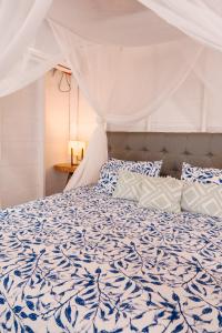 a bedroom with a bed with a blue and white comforter at Paraíso Natural Ecohotel in San Bernardo del Viento