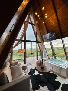 salon z dużym oknem i wanną w obiekcie Cabanna Bella Vista w mieście Serra de São Bento