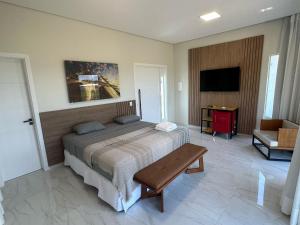 a bedroom with a bed and a table and a tv at Villa'S Roraima - Pousada & Natureza in Boa Vista