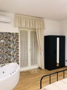 a bathroom with a white tub and a window at Green House GM in Gragnano