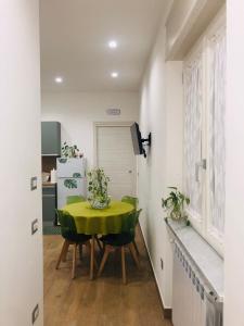 a dining room with a green table and chairs at Green House GM in Gragnano +3 photos