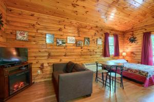 ein Schlafzimmer mit einem Bett und einem Tisch mit einem Kamin in der Unterkunft Blue Rose Cabins - Cozy Cabin in Logan