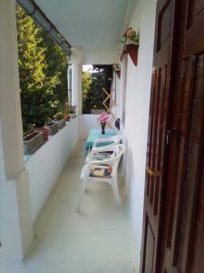 una mesa y sillas en el porche de una casa en Rainforest vendeghaz, en Hollóháza