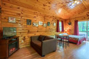 ein Wohnzimmer mit einem Sofa und einem Tisch in einer Hütte in der Unterkunft Blue Rose Cabins - Cozy Cabin in Logan
