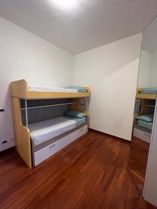 サバウディアにあるSabaudia Jolie Maisonの二段ベッド2組が備わるウッドフロアの客室です。