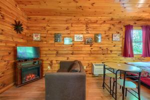 ein Wohnzimmer mit Kamin in einer Blockhütte in der Unterkunft Blue Rose Cabins - Cozy Cabin in Logan + 4 Fotos