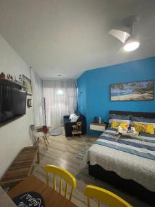 1 dormitorio con cama y pared azul en Loft Condado Mangaratiba, en Mangaratiba