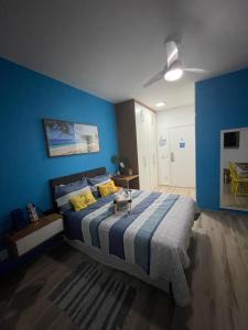 um quarto azul com uma cama e uma ventoinha de tecto em Loft Condado Mangaratiba em Mangaratiba