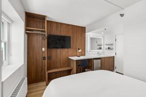 a bedroom with a bed and a desk and a sink at Uptown Inn by Vantaggio Suites in San Diego
