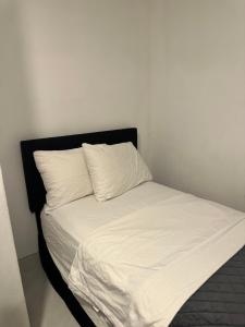 a bed with white sheets and a black headboard at small room with sharing bathroom in Boca Raton