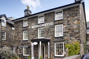 an old stone building with a sign on it at Y Meirionnydd Boutique Hotel in Dolgellau