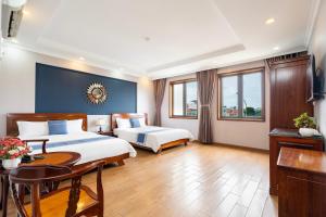 a hotel room with two beds and a desk at CAMY Hotel Vung Tau in Vung Tau