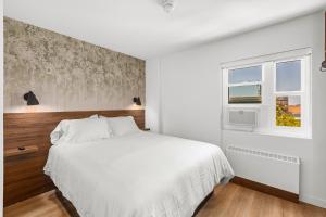 a bedroom with a white bed and a window at Uptown Inn by Vantaggio Suites in San Diego