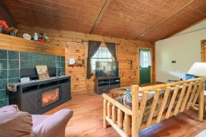 a living room with a fireplace in a log cabin at Blue Rose Cabins - Lincoln Log Cabin in Logan +12 photos