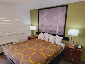 een hotelkamer met een bed met een grote foto aan de muur bij Super 8 by Wyndham El Centro North in El Centro