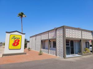 ein Geschäft mit einem Schild vor einem Gebäude in der Unterkunft Super 8 by Wyndham El Centro North in El Centro