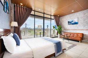 a bedroom with a large bed and a large window at CAMY Hotel Vung Tau in Vung Tau