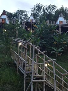 a group of cottages with lights in the grass at El Guadual Glamping in Ibagué