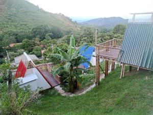 a house on a hill with a balcony and a deck at El Guadual Glamping in Ibagué