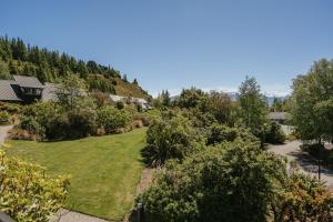 uma vista para um quintal com arbustos e árvores em Edgewater Hotel em Wanaka