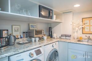 a kitchen with a washing machine and a microwave at Gorgeous 1 Bedroom Space in Seattle
