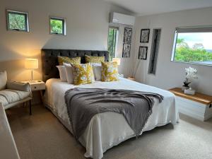 a bedroom with a large bed and a window at Peppertree lodge in Havelock North