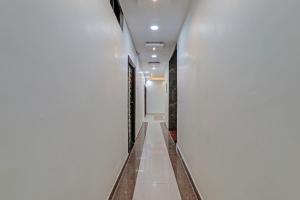 un corridoio di un edificio con pareti bianche e pavimenti bianchi di Super Collection O Oyo Townhouse Lemonade Shyam Nagar a Juhi Bari