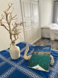 a table with a blue table cloth with a book and a vase at Astypalea Apartments in Astypalaia Town