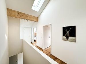 ein weißer Flur mit einem Bild von einem Hirsch an der Wand in der Unterkunft Maisonette Hochgrat in Oberstaufen