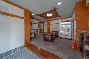 a living room with a refrigerator and a kitchen at KOMOREBI HOSTEL-your cozy place- in Takayama
