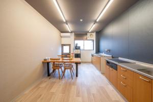 高山的住宿－KOMOREBI HOSTEL-your cozy place-，一个带桌椅的大厨房