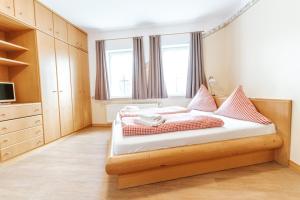 Un dormitorio con una cama con almohadas rojas y blancas. en Hof Köhne - Altes Bauernhaus - Bauernwohnung, en Schmallenberg