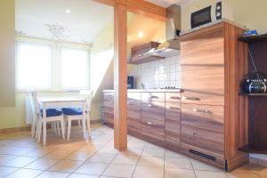 Una cocina con armarios de madera y una mesa. en Hof Köhne - Altes Bauernhaus - Wohnung Dachstube rechts, en Schmallenberg