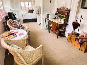 uma sala de estar com uma cama, uma mesa e cadeiras em Kenilworth House SC em Kenilworth
