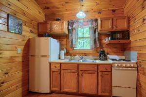 a kitchen with a refrigerator and a sink at Blue Rose Cabins - Lovebirds Cabin in Logan