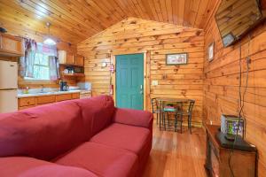 a living room with a red couch in a cabin at Blue Rose Cabins - Lovebirds Cabin in Logan