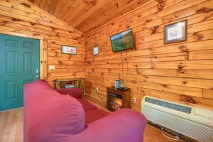 a living room with a red couch and a fireplace at Blue Rose Cabins - Lovebirds Cabin in Logan