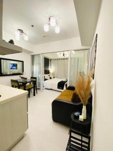 a living room with a bed and a dining room at Beach Front Living in the Heart of the City, AZURE Residences in Manila