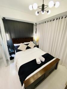 1 dormitorio con 1 cama con 2 toallas en Beach Front Living in the Heart of the City, AZURE Residences, en Manila