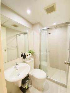 a bathroom with a toilet and a sink and a shower at Beach Front Living in the Heart of the City, AZURE Residences in Manila
