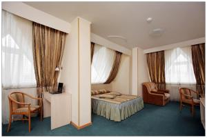 a hotel room with a bed and a desk and chairs at Colibri Hotel in Novosibirsk