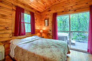 a bedroom with a bed in a log cabin at Blue Rose Cabins - Lovebirds Cabin in Logan +5 photos