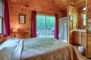 a bedroom with a bed in a log cabin at Blue Rose Cabins - Lovebirds Cabin in Logan